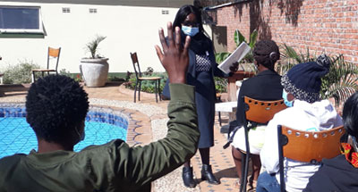 Image of students wearing masks conducting school outside during COVID.